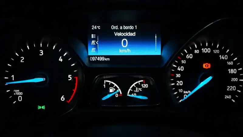 A car's instrument cluster lit up in blue, with the speedometer at zero.